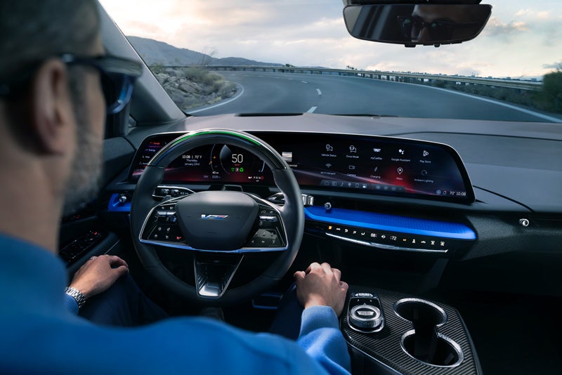 Front View of the 2026 OPTIQ-V Driving Through the Dusk Utilizing its Headlights | Buzz Chew Cadillac in SOUTHAMPTON NY